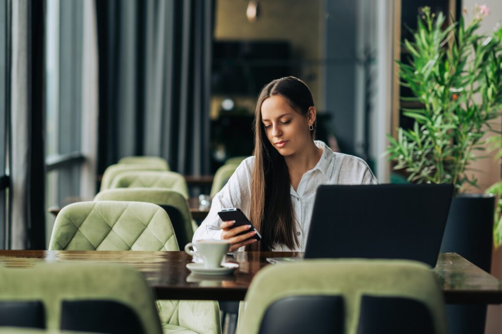 A young elegant freelancer is sitting in a cafe and working a remote job